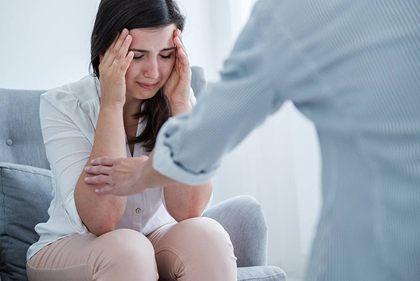 Upset woman being consoled during therapy appointment