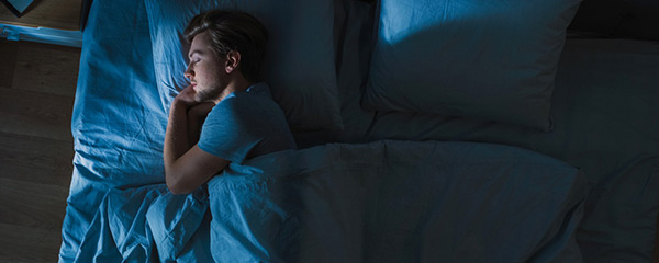 Man sleeping in blue bed