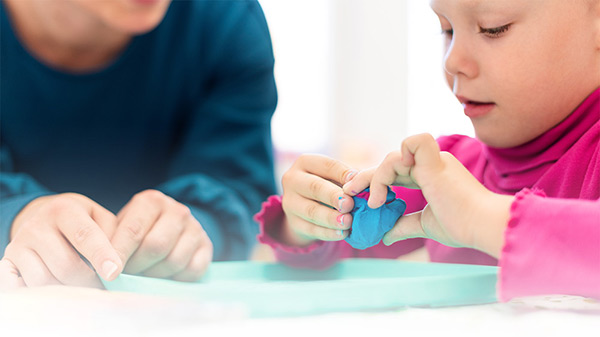 Child playing with playdough in therapy